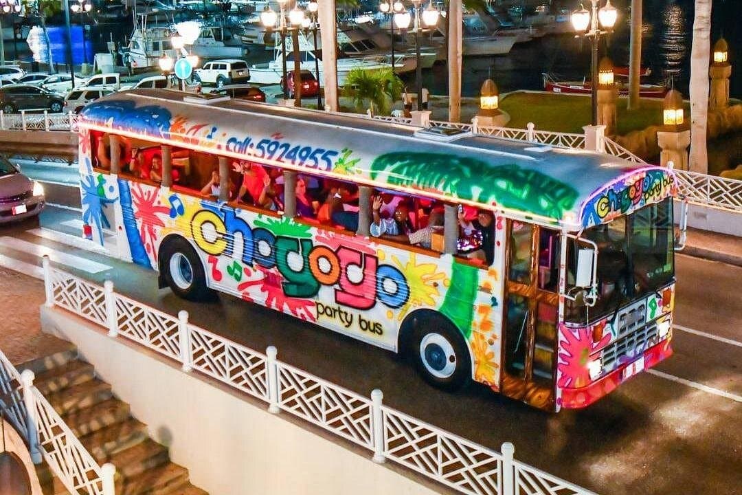 Chogogo Party Bus Aruba at night with guests dancing and drinks on board.