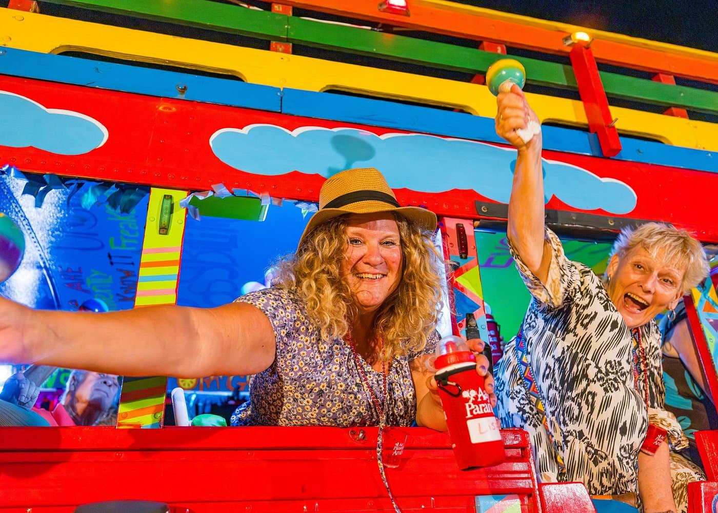 Kukoo Kunuku open-air party bus lit up for an Aruba nightlife tour.